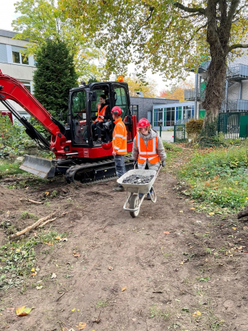 Schüler*innen bei den Vorbereitungsarbeiten für die Terrasse im Schulgarten Schüler*innen bei den Vorbereitungsarbeiten für die Terrasse im Schulgarten