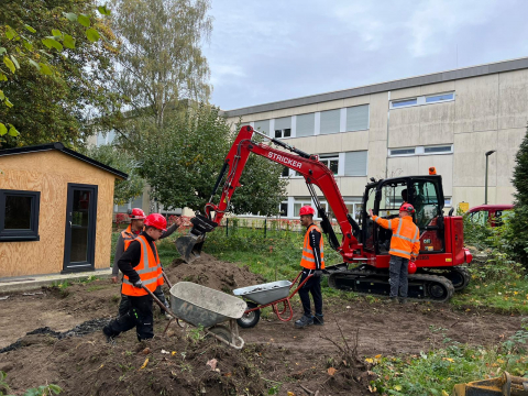 Schüler*innen bei den Vorbereitungsarbeiten für die Terrasse im Schulgarten Schüler*innen bei den Vorbereitungsarbeiten für die Terrasse im Schulgarten