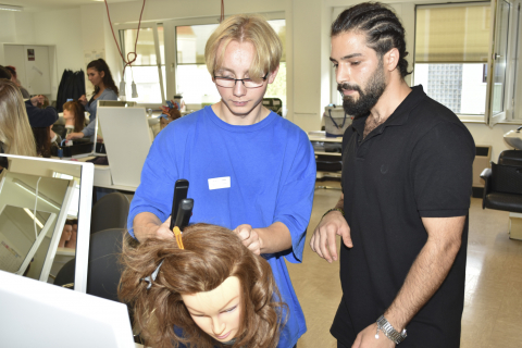 Ein Schüler beim angeleiteten Workshop in der Friseurwerkstatt