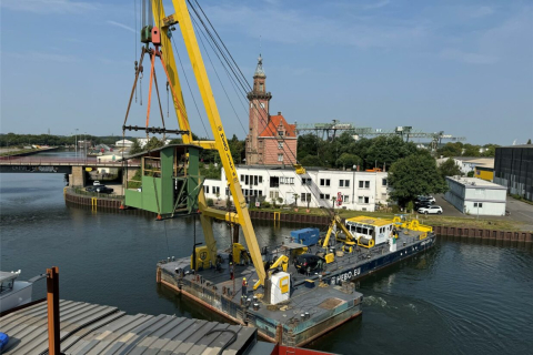 Mit Hilfe des Schwimmkrans wurden die Einzelteile des Krans an die Hafenpromenade gehoben Mit Hilfe des Schwimmkrans wurden die Einzelteile des Krans an die Hafenpromenade gehoben