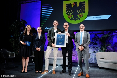 Tobias Frank (Mitte) hat in Berlin den TÜV-Award „New Mobility City“ 2026 für die Stadt Dortmund entgegengenommen.